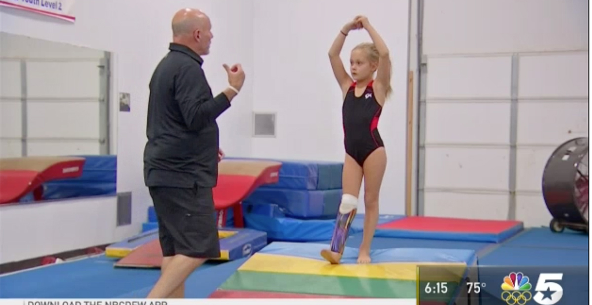 Gymnastics coach instructs Aspen