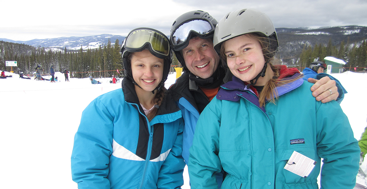 Dr. Ellis on the ski slopes with two patients.
