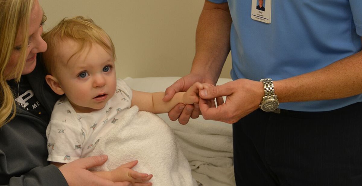 Doctor examines child's hand