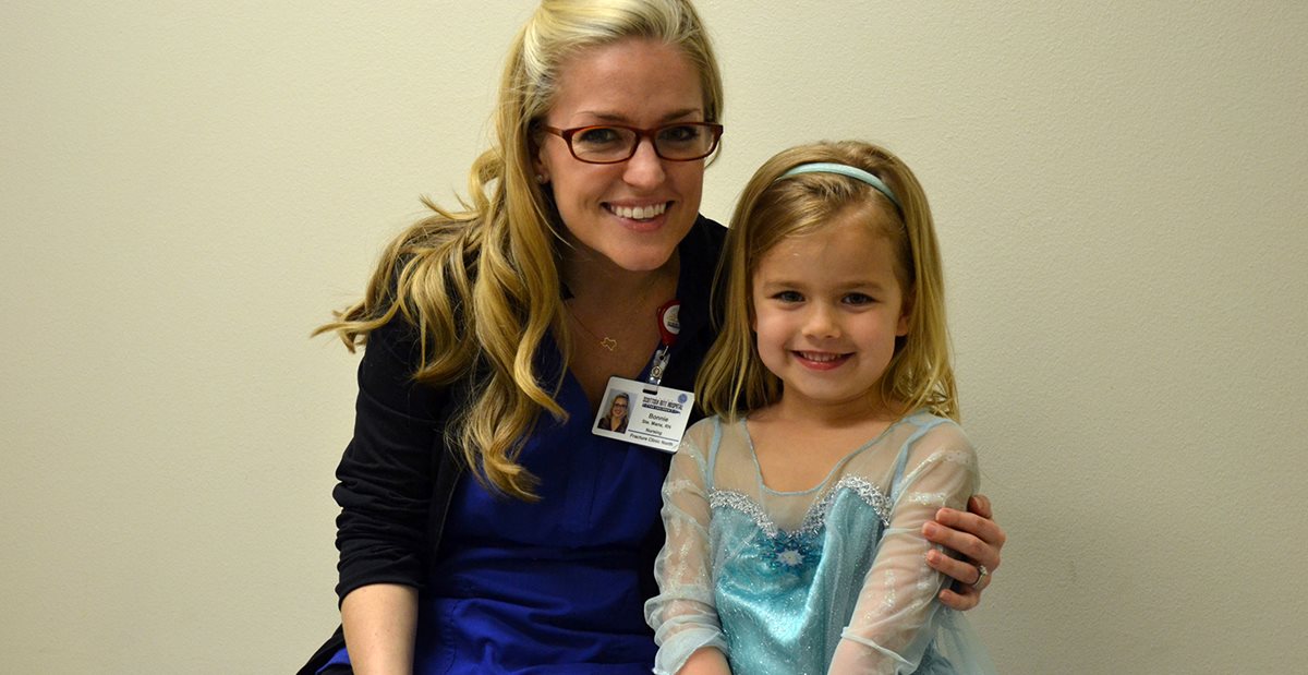 Nurse at the Texas Scottish Rite Hospital for Children Fracture Clinic assists small girl dressed as princess
