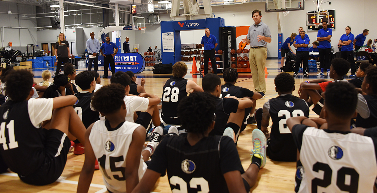 Dr. Ellis and other staff talking to participants of the Mavs Academy combine.
